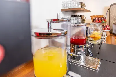 a blender filled with orange juice on top of a counter at Hotel Heide Park in Ora/Auer