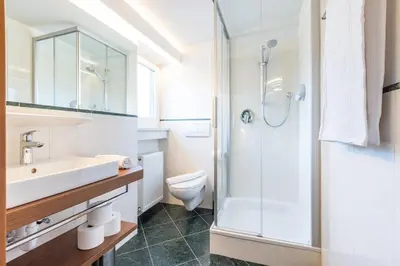 a bathroom with a sink toilet and a shower at Hotel Heide Park in Ora/Auer