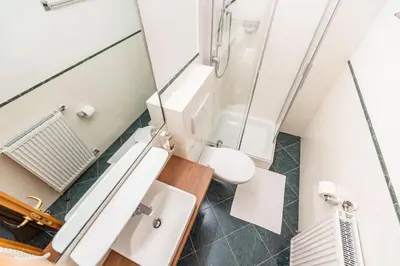 a bathroom with a shower and a toilet and a sink at Hotel Heide Park in Ora/Auer