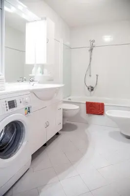 a white bathroom with a washing machine and a sink at Cademia in Ortisei