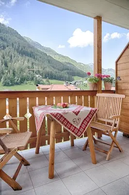 a table and two chairs on a balcony with a view at Cademia in Ortisei