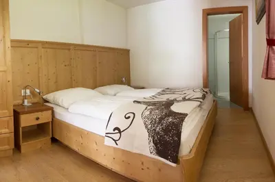 a bedroom with a bed with a black and white comforter at Cademia in Ortisei