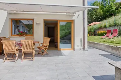 a patio with a table and chairs and a house at Cademia in Ortisei