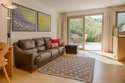 a living room with a leather couch and a table at Cademia in Ortisei