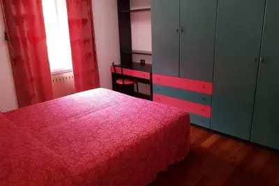 a bedroom with a bed and a desk and cabinets at Casa da Rina in Siror