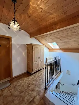 a room with a wooden ceiling and a staircase at Voldersberghof in Cortaccia