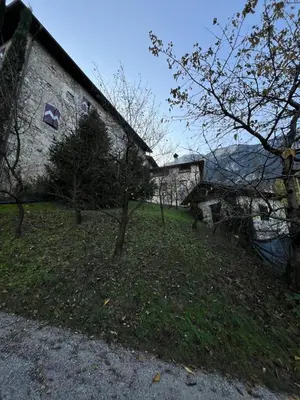 a building with trees in the grass next to a building at Voldersberghof in Cortaccia