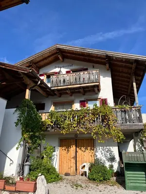 a building with a wooden door and a balcony at Voldersberghof in Cortaccia
