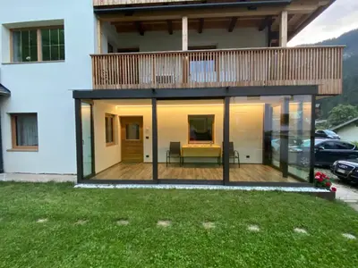 a house with glass walls and a deck at Pradat in La Valle