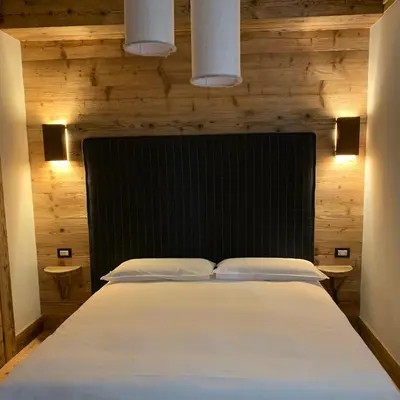 a bedroom with a large bed with a black headboard at Piccolo gioiello di montagna in Villanova
