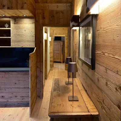 a hallway in a log cabin with a table and a lamp at Piccolo gioiello di montagna in Villanova