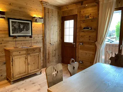 a dining room with wooden walls and a table and chairs at Piccolo gioiello di montagna in Villanova