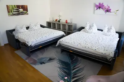 two twin beds in a room with wooden floors at Casa Rudy in Bolzano
