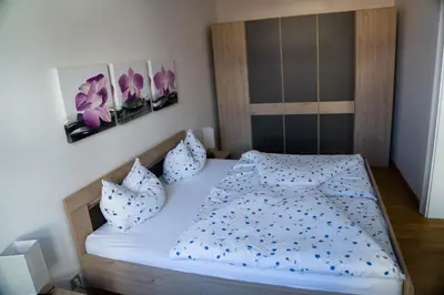 a bedroom with a bed with blue sheets and pillows at Casa Rudy in Bolzano