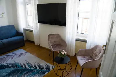 a living room with two chairs and a tv at Casa Rudy in Bolzano