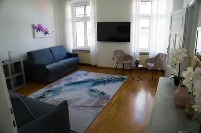 a living room with a blue couch and chairs at Casa Rudy in Bolzano
