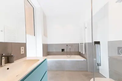 a bathroom with a tub and a sink at Apartments Leonardo in Bolzano