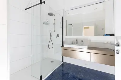 a white bathroom with a sink and a shower at Apartments Leonardo in Bolzano