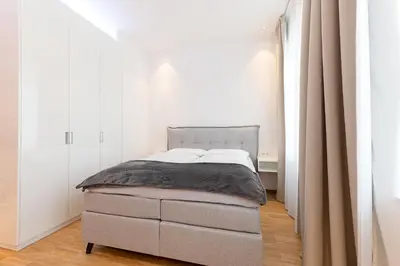 a bedroom with a bed in a white room at Apartments Leonardo in Bolzano