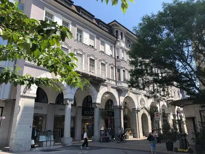 a large building with people walking in front of it at Apartments Leonardo in Bolzano