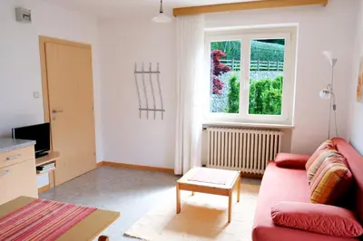 a living room with a red couch and a window at Apartment Weitblick - Alpstay in Naturno