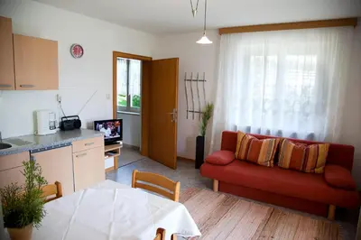 a living room with a red couch and a table at Apartment Weitblick - Alpstay in Naturno