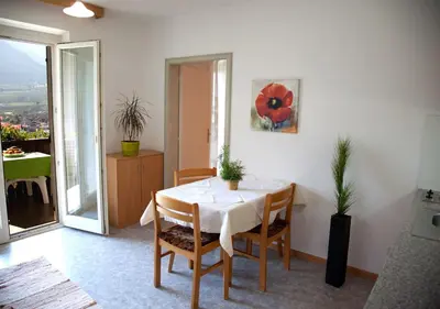 a dining room with a white table and chairs at Apartment Weitblick - Alpstay in Naturno