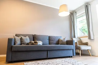 a blue couch in a living room with a lamp at Flow Apartments Margareta in Parcines