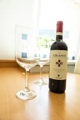 a bottle of wine and two glasses on a table at Flow Apartments Margareta in Parcines