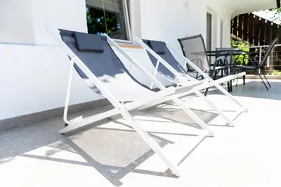 a group of chairs sitting on a porch at Flow Apartments Margareta in Parcines