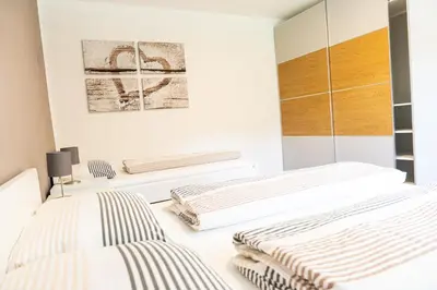 two beds in a bedroom with white walls at Flow Apartments Margareta in Parcines
