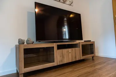 a flat screen tv on top of a wooden entertainment center at Flow Apartments Margareta in Parcines