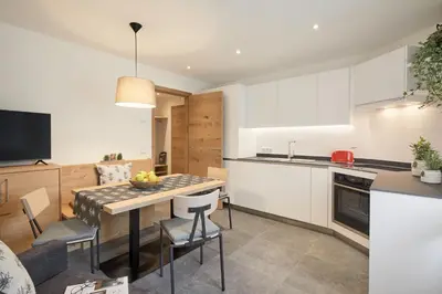 a kitchen and dining room with a table and chairs at daHoam Appartamenti in Rasùn di Sotto
