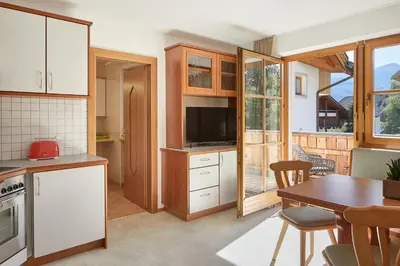 a kitchen with a table and a dining room at daHoam Appartamenti in Rasùn di Sotto