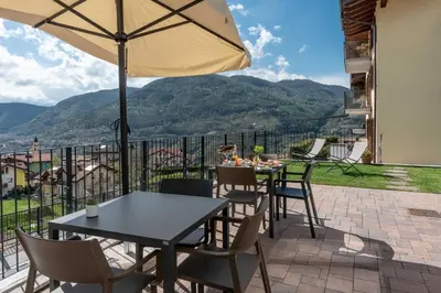 a patio with a table and chairs and an umbrella at La Pao Bed and Breakfast in Segonzano