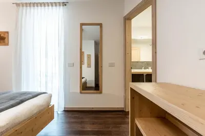 a bedroom with a bed and a mirror at La Pao Bed and Breakfast in Segonzano