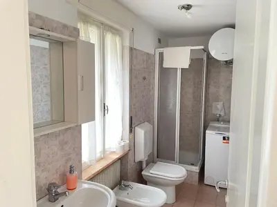a bathroom with a sink and a toilet and a window at SUITE DOLOMITI Appartamento in Falcade