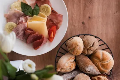 two plates of food on a wooden table at MyLiving - Hotel B&B by Majestic Resorts Dolomites in San Lorenzo di Sebato