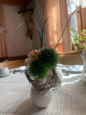 a vase with flowers in it on a table at Garni Guflhof in Caldaro
