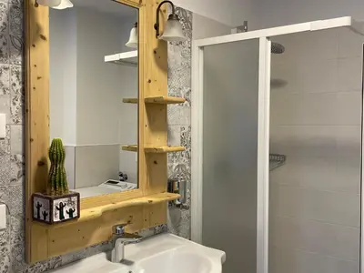 a bathroom with a wooden shelf above a sink at RESIDENZA LA CANONICA in Brez