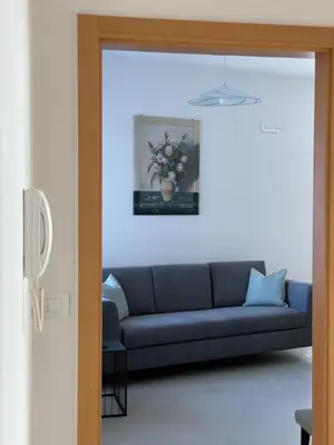a blue couch in a living room with a vase of flowers at RESIDENZA LA CANONICA in Brez