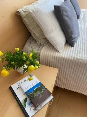 a book on a table next to a bed with yellow flowers at RESIDENZA LA CANONICA in Brez