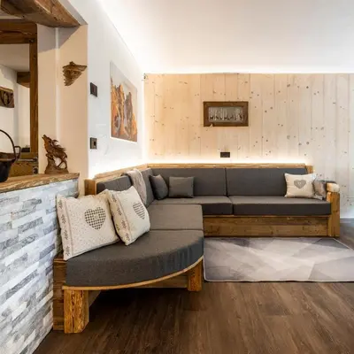 a living room with a couch and a fireplace at Sa Mont Home - Moderno appartamento con parcheggio, sauna e deposito sci in Bellamonte