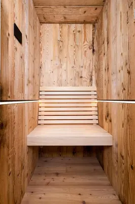 a wooden sauna with a bench in a room at Sa Mont Home - Moderno appartamento con parcheggio, sauna e deposito sci in Bellamonte
