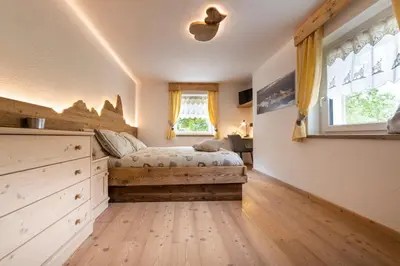 a bedroom with a bed and a window at Sa Mont Home - Moderno appartamento con parcheggio, sauna e deposito sci in Bellamonte