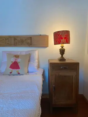 a bedroom with a bed with a lamp on a night stand at Casa Curti in Gosaldo