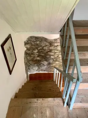 a staircase in a room with a stone wall at Casa Curti in Gosaldo