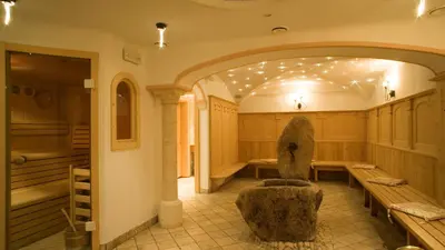 a room with a bench and a chair in it at Pension Angelo in Corvara in Badia