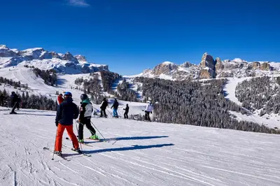 a group of people skiing down a snow covered mountain at Pension Angelo in Corvara in Badia