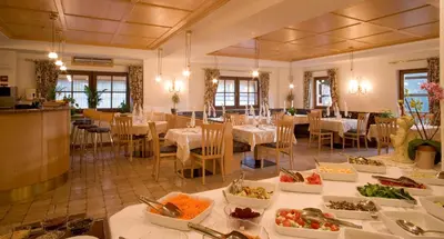 a dining room with tables with plates of food at Pension Angelo in Corvara in Badia